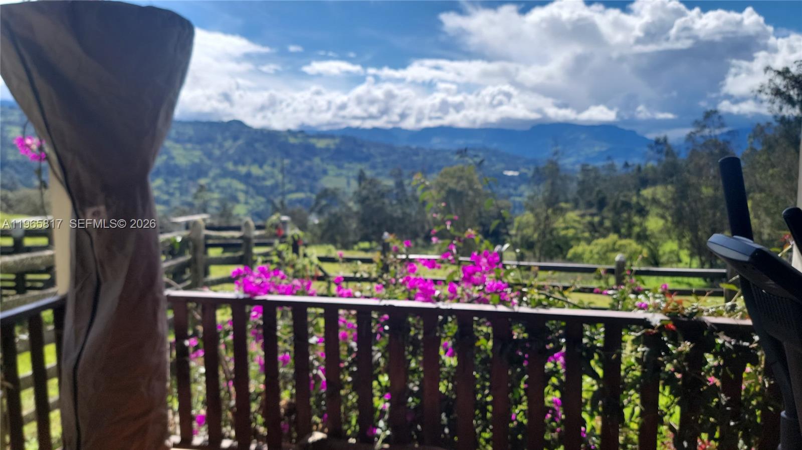 A wooden balcony railing overlooks a lush mountain landscape with blooming bougainvillea — Palenque 1 E Gama Cundinamarca, Vereda Palenque 1, 2512247, FL