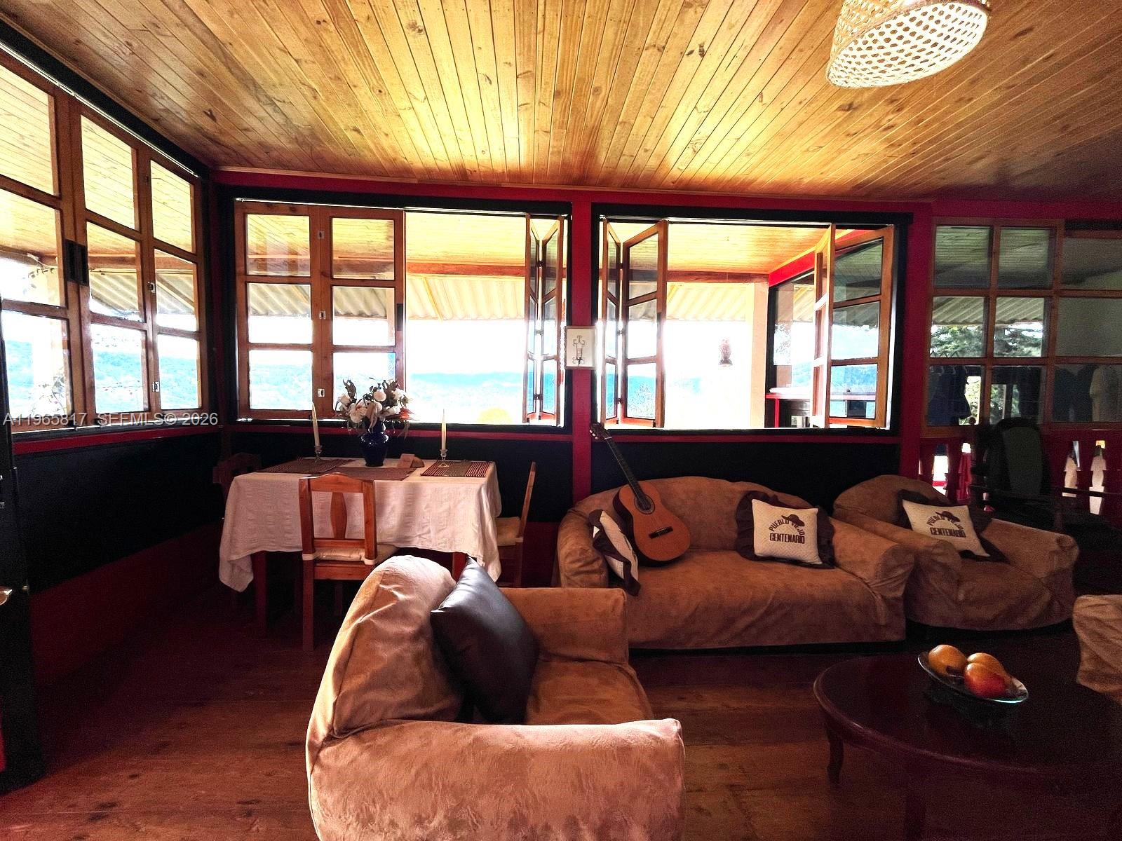 A rustic living and dining area features wood-paneled ceilings, large windows, and brown upholstered furniture — Palenque 1 E Gama Cundinamarca, Vereda Palenque 1, 2512247, FL