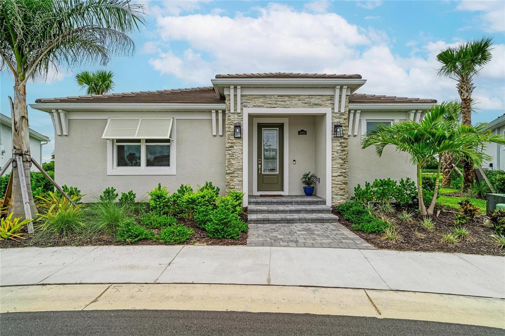 A single-story house with a stone-accented entryway, a paved walkway, and palm trees — 4064 SANTA CATERINA BOULEVARD UNIT 101, LAKEWOOD RANCH, FL