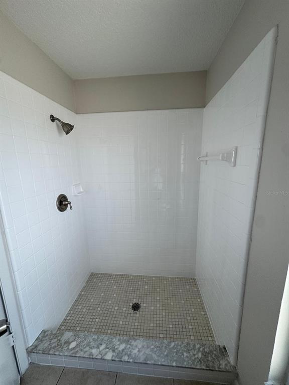 A walk-in shower features white subway tile walls, a mosaic tile floor, and a marble threshold — 5272 LONESOME DOVE DRIVE, KISSIMMEE, FL
