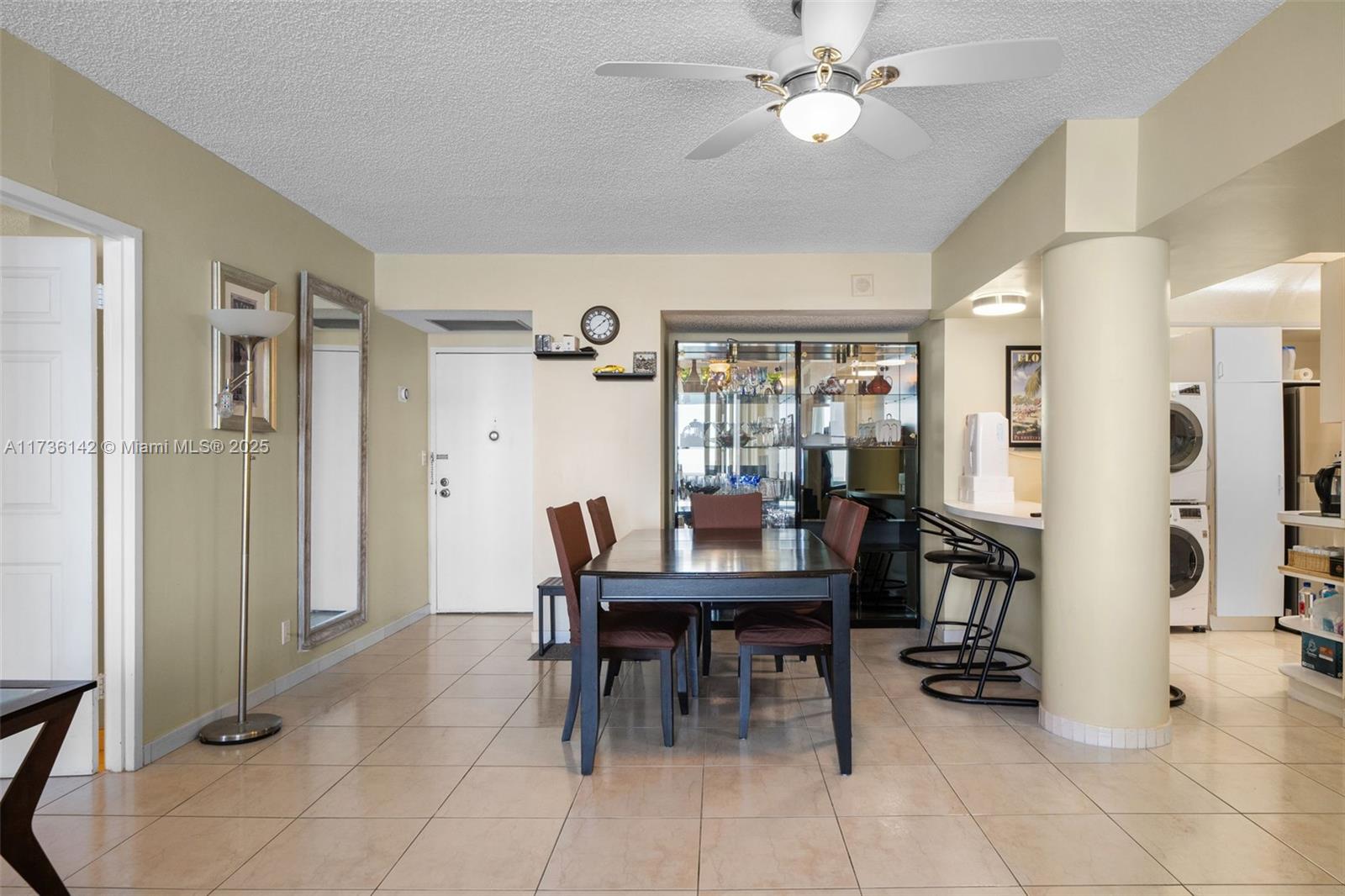 A dining area features a dark wood table, chairs, a glass display cabinet, and tile flooring — 3725 S Ocean Dr # 1110, Hollywood FL 33019, HOLLYWOOD, FL