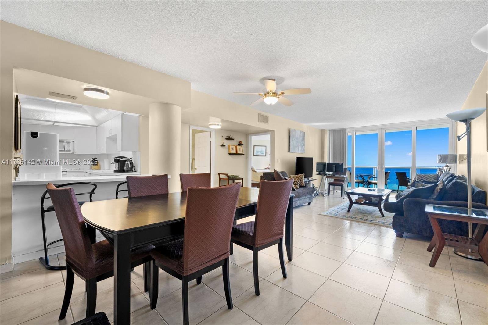 An open-concept living and dining area features tile floors, a kitchen, and ocean views — 3725 S Ocean Dr # 1110, Hollywood FL 33019, HOLLYWOOD, FL