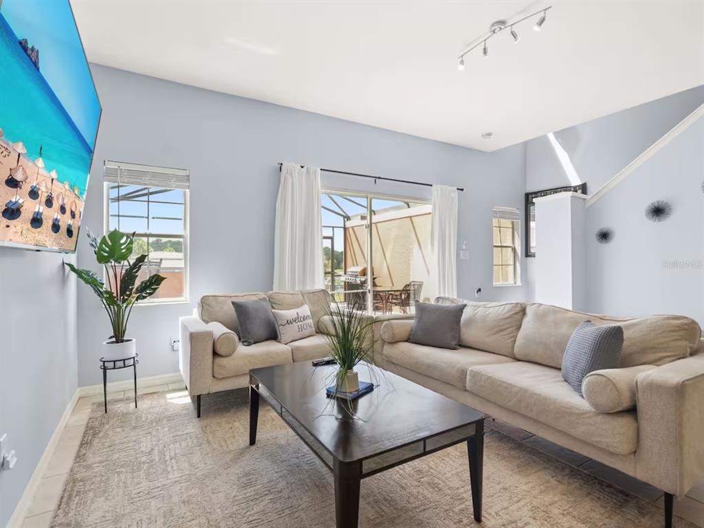 A living room features light blue walls, a beige sectional sofa, and a coffee table — 3113 YELLOW LANTANA LANE, KISSIMMEE, FL