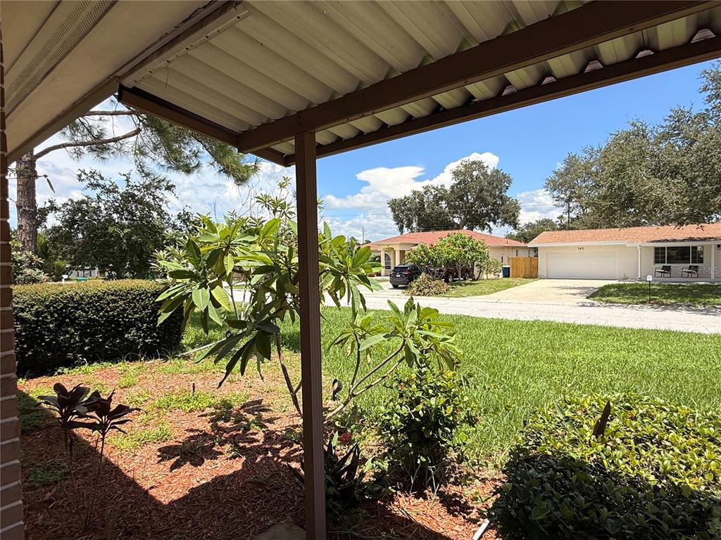 A view from a covered porch looking out toward a suburban street and neighboring houses — 164 PINEWOOD AVENUE, CLEARWATER, FL