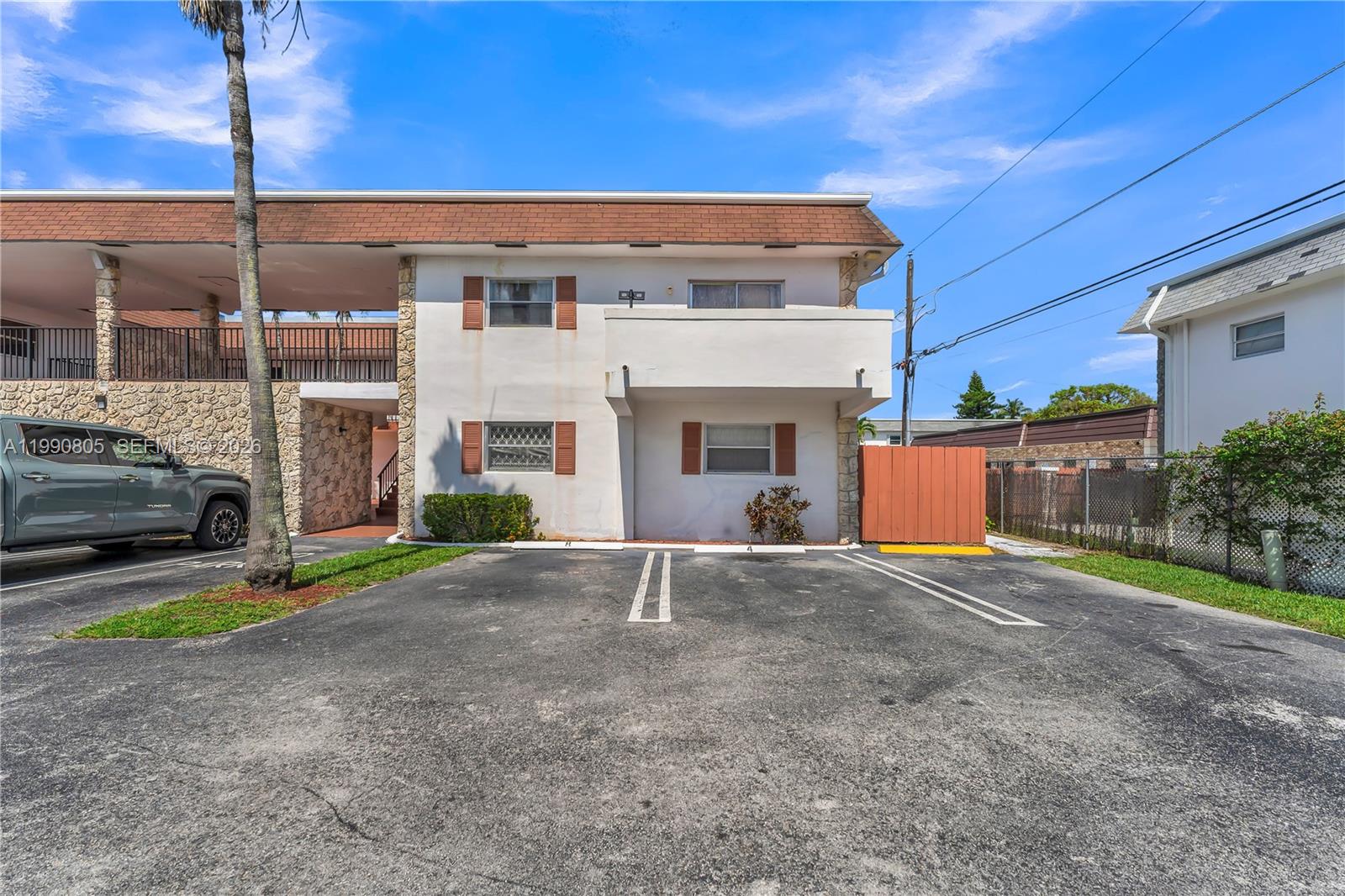 A two-story apartment building exterior features a parking lot, stone accents, and brown shutters — 321 SW 1st Ct # 4, Pompano Beach FL 33060, POMPANO BEACH, FL