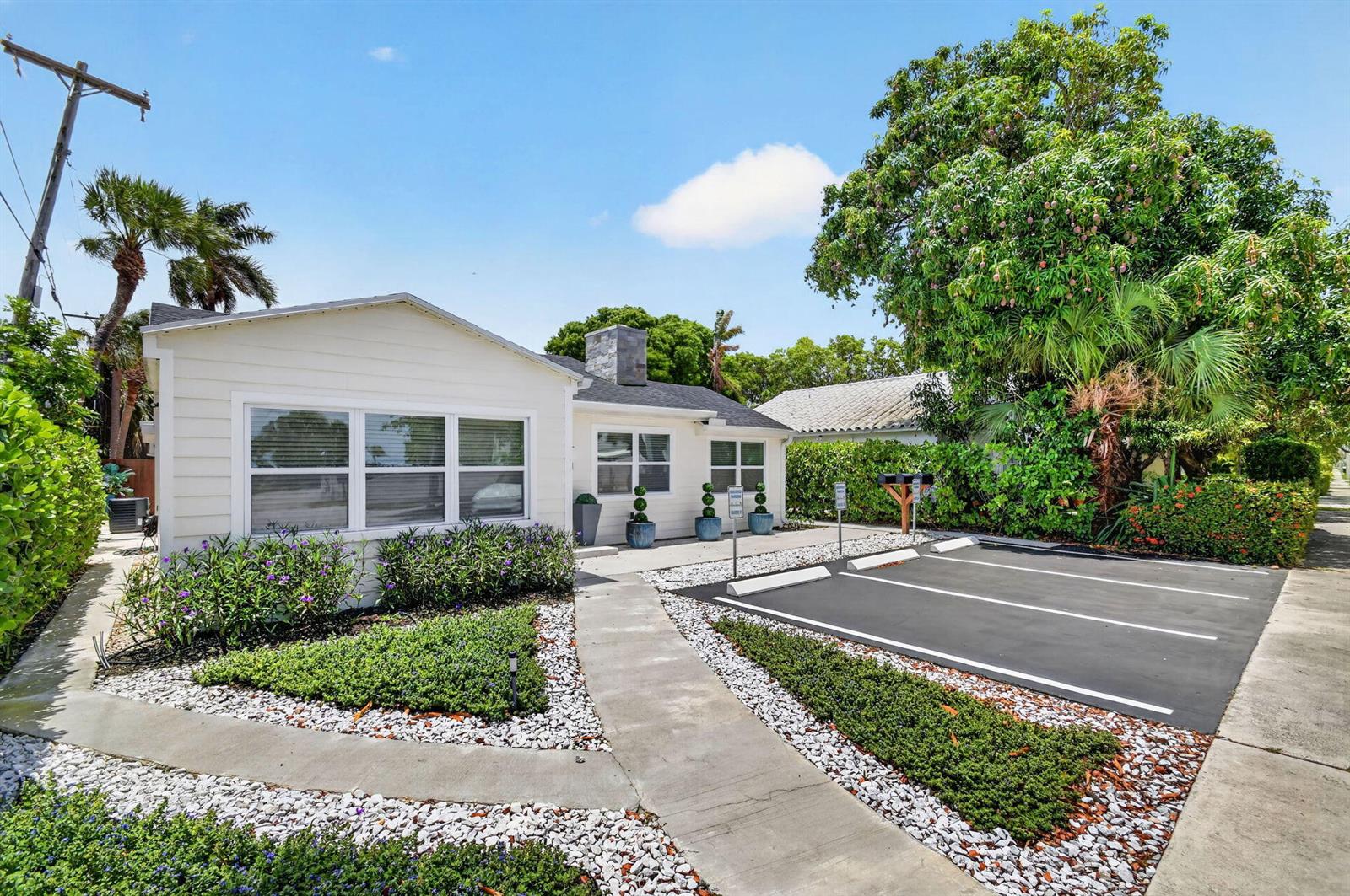 A single-story white house features a paved parking area, landscaping, and a concrete walkway — 4811 N Flagler Drive, West Palm Beach FL 33407, WEST PALM BEACH, FL