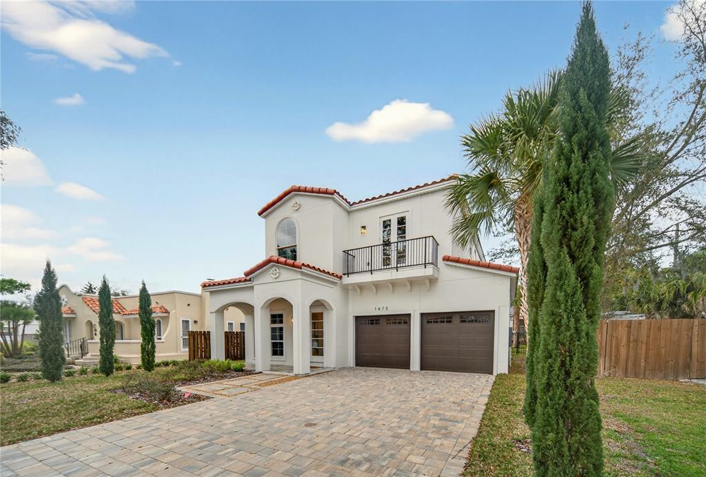 A two-story stucco house with a tile roof, two-car garage, and a front balcony — 1473 BERKSHIRE AVENUE, WINTER PARK, FL