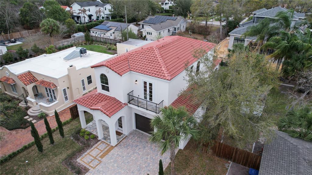 An aerial view shows a two-story white house with a red tile roof and balcony — 1473 BERKSHIRE AVENUE, WINTER PARK, FL