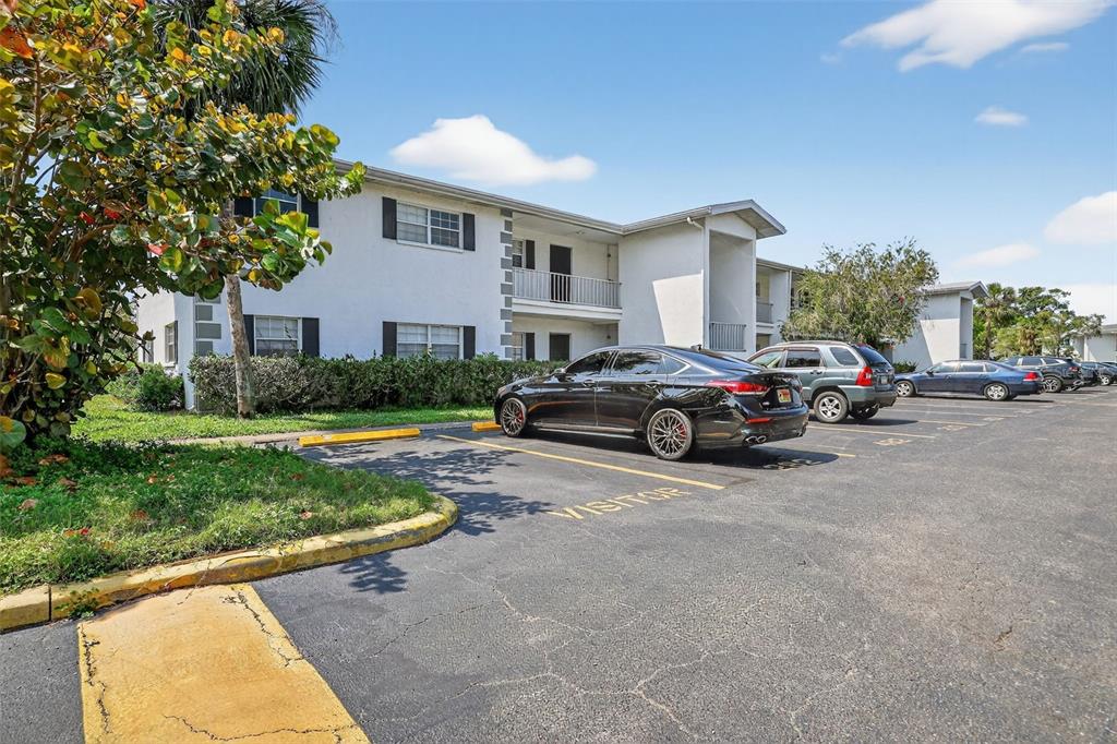 A two-story apartment building with a parking lot featuring marked visitor spaces in front — 4509 3RD STREET CIRCLE W UNIT 283, BRADENTON, FL