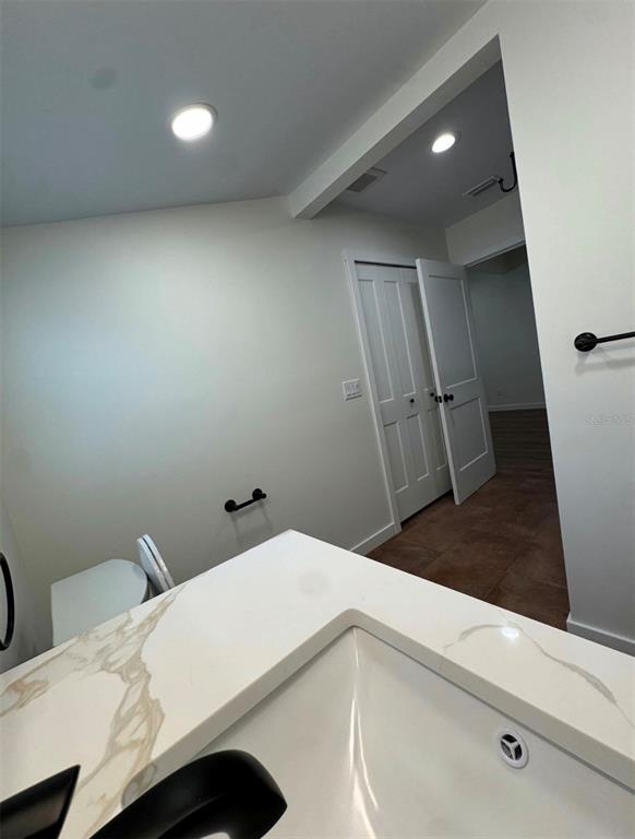 A bathroom features a white marble-patterned vanity countertop, a black faucet, and a white door — 14 MILL STREET, TARPON SPRINGS, FL