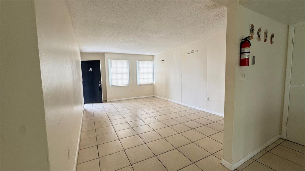 An empty room with beige tile flooring, white walls, and two windows — 2777 L B MCLEOD ROAD UNIT 2777A, ORLANDO, FL