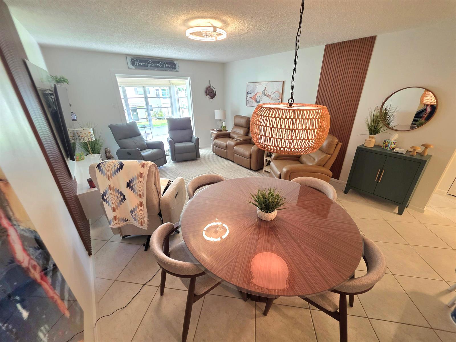 A dining area with a round table and pendant light overlooks a living room space — 5680 SW 3rd Place # 206, Margate FL 33068, MARGATE, FL