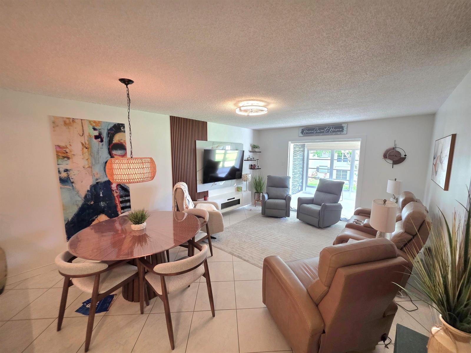 An open-concept living and dining area features tile flooring, a round table, and leather recliners — 5680 SW 3rd Place # 206, Margate FL 33068, MARGATE, FL