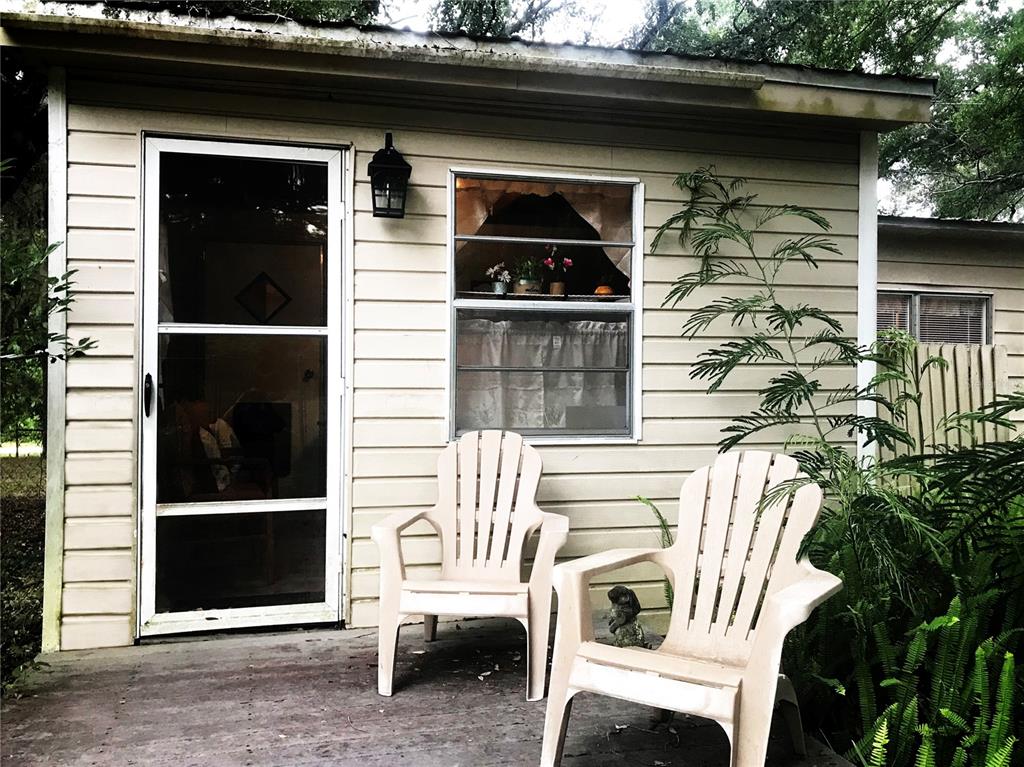 A small, light-colored shed with a screen door, a window, and two plastic chairs outside — 118 MILLCREEK DRIVE, MELROSE, FL