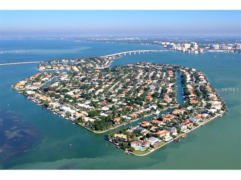 An aerial view shows a residential island community surrounded by water with a bridge nearby — 338 BIRD KEY DRIVE, SARASOTA, FL