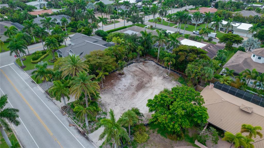 An aerial view shows a vacant residential lot surrounded by palm trees and neighboring houses — 338 BIRD KEY DRIVE, SARASOTA, FL