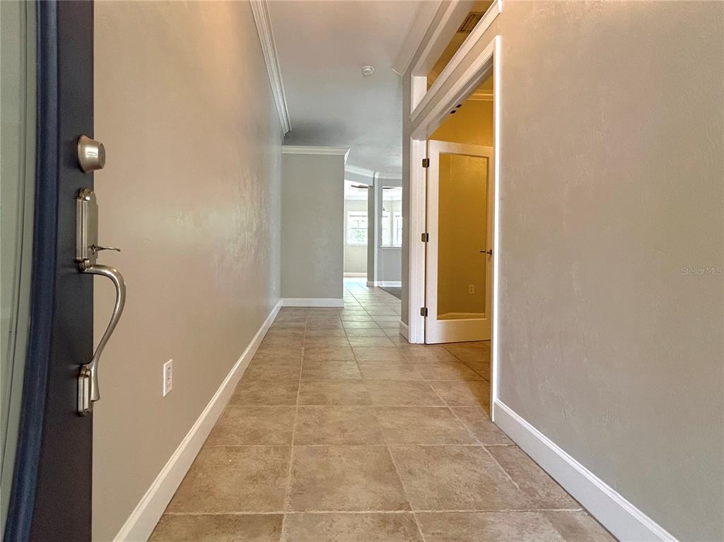 A tiled entryway leads into a hallway with a glass-paneled door on the right — 14424 NW 22ND PLACE, NEWBERRY, FL