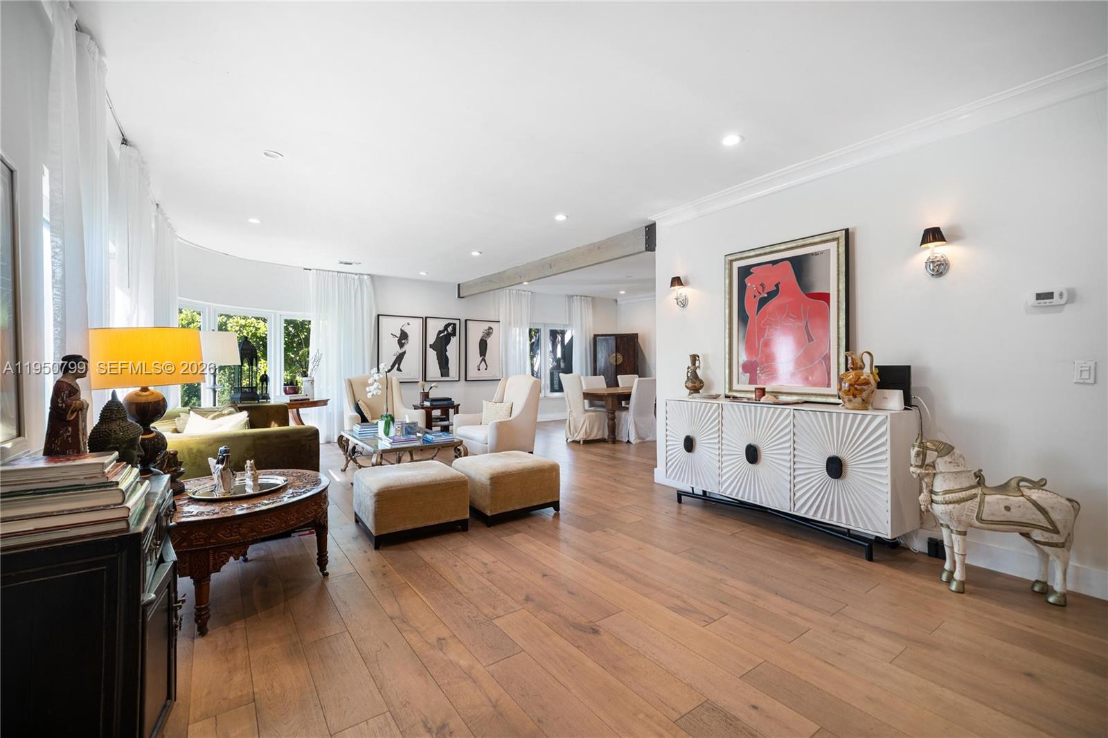 A spacious living room features light wood flooring, white walls, and a modern white sideboard — 463 W 62nd St, Miami Beach FL 33140, MIAMI BEACH, FL