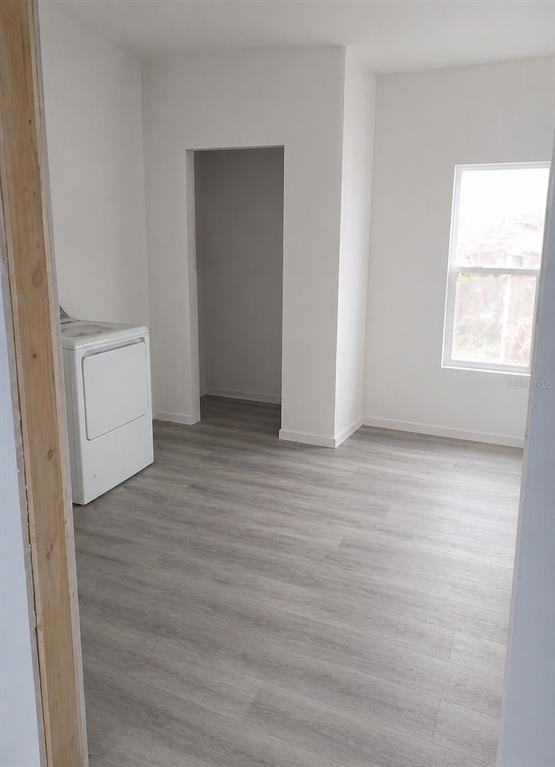 A laundry room with light wood-look flooring, white walls, a window, and a white dryer — 2859 ORANGE STREET, MARIANNA, FL