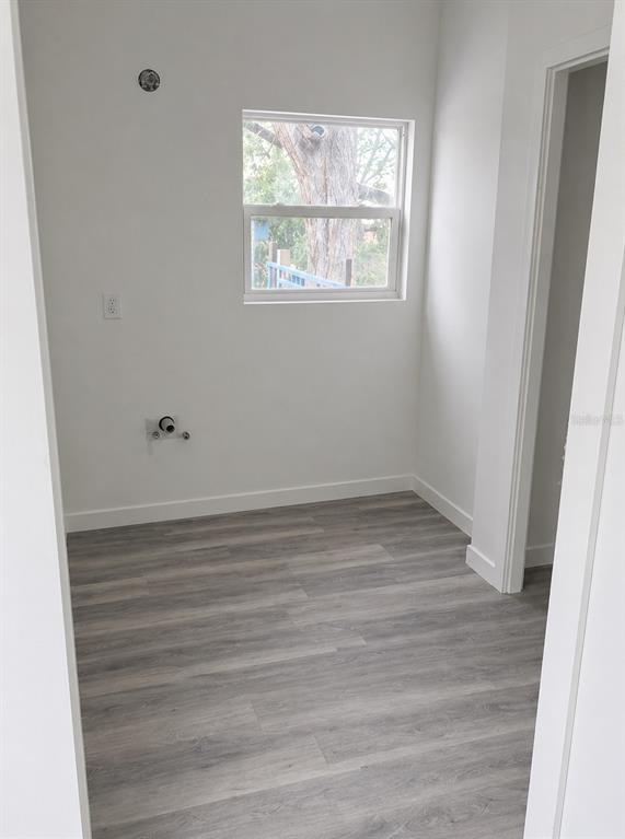 A small, empty laundry room with light gray wood-look flooring and a single window — 2859 ORANGE STREET, MARIANNA, FL
