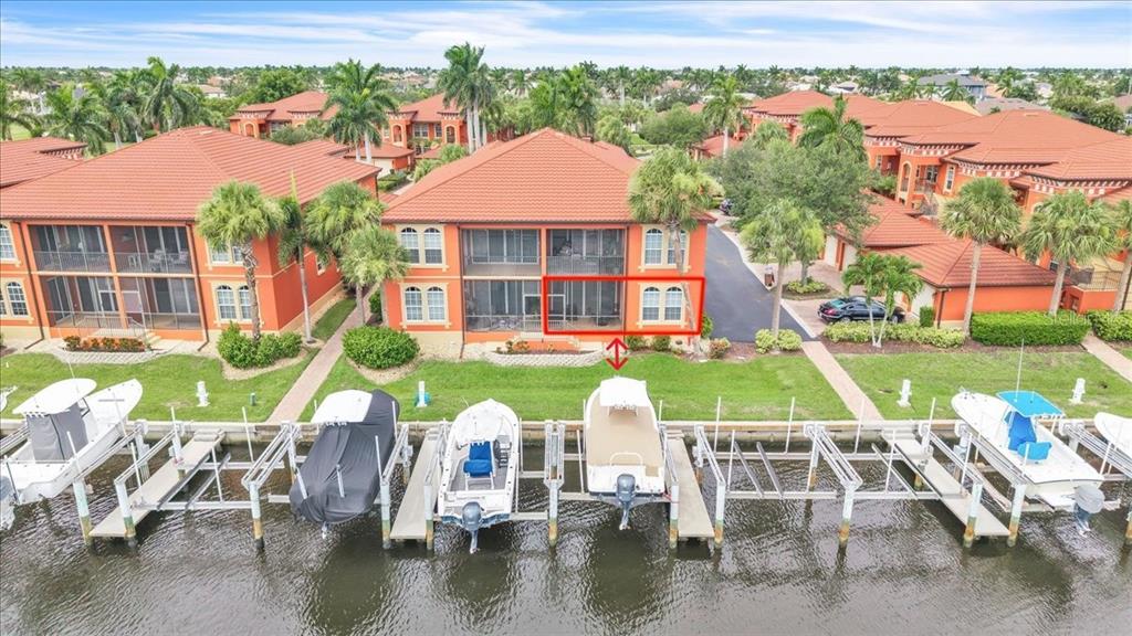 An aerial view of a waterfront condo building with boat slips and a red-outlined balcony — 3500 MONDOVI COURT UNIT 811, PUNTA GORDA, FL