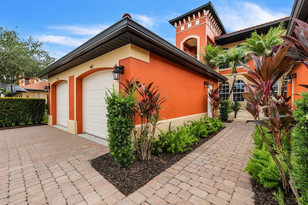 An orange stucco house with a two-car garage and a brick paver driveway — 3500 MONDOVI COURT UNIT 811, PUNTA GORDA, FL