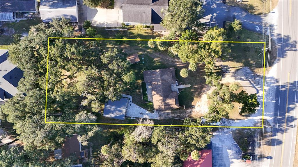 An aerial view shows a house and detached structure on a lot outlined in yellow — 5062 N OCEAN SHORE BOULEVARD, PALM COAST, FL