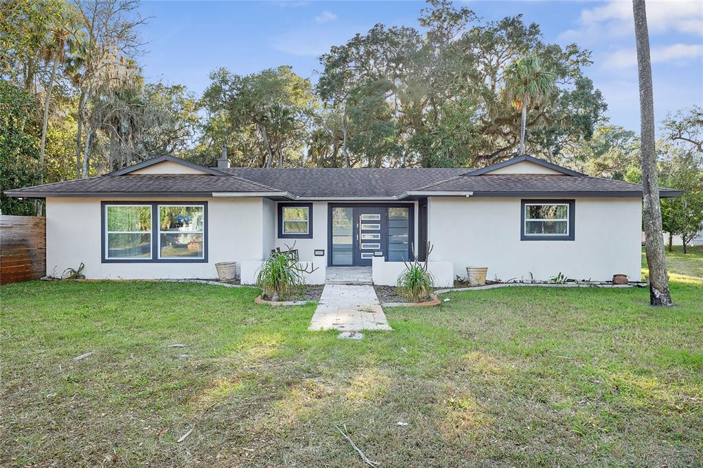 A single-story house with a light-colored exterior, dark trim, and a central double-door entrance — 5062 N OCEAN SHORE BOULEVARD, PALM COAST, FL