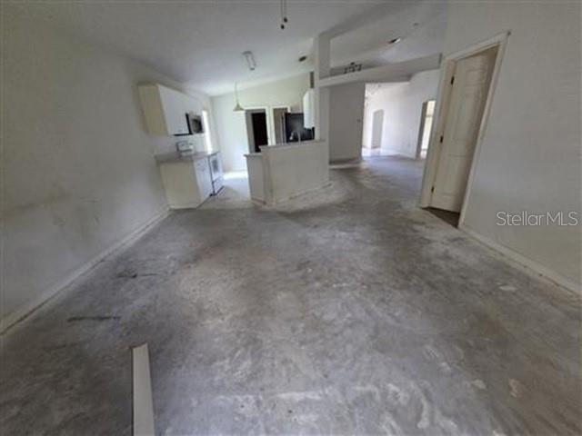 An interior view of an open-concept living area with concrete floors and a kitchen — 1584 FUJI DRIVE, TITUSVILLE, FL