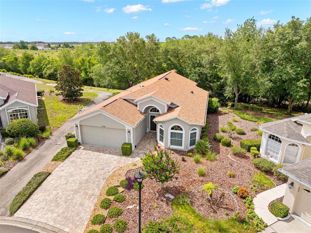 An aerial view of a single-story house with a tan roof and paved driveway — 11750 TEAPOT COURT, SPRING HILL, FL