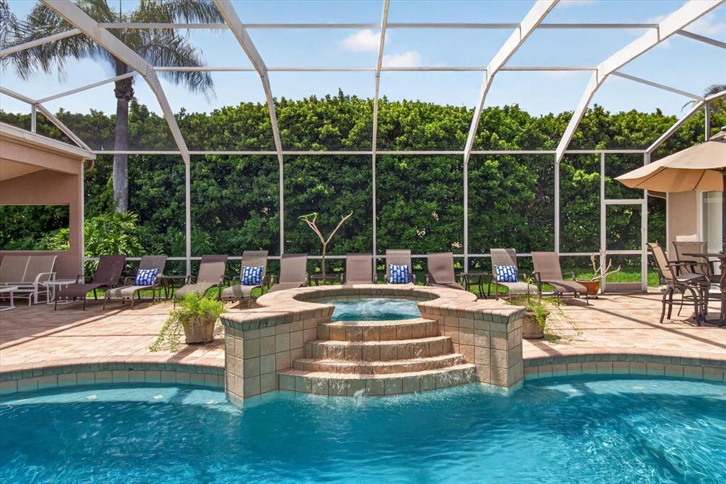 A screened-in patio features a swimming pool with an integrated raised spa and waterfall — 4052 CAPITOL DRIVE, PALM HARBOR, FL