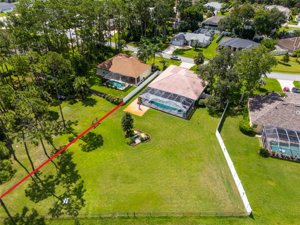 An aerial view shows a residential backyard with a swimming pool and a fenced lawn — 87 EASTWOOD DRIVE, PALM COAST, FL