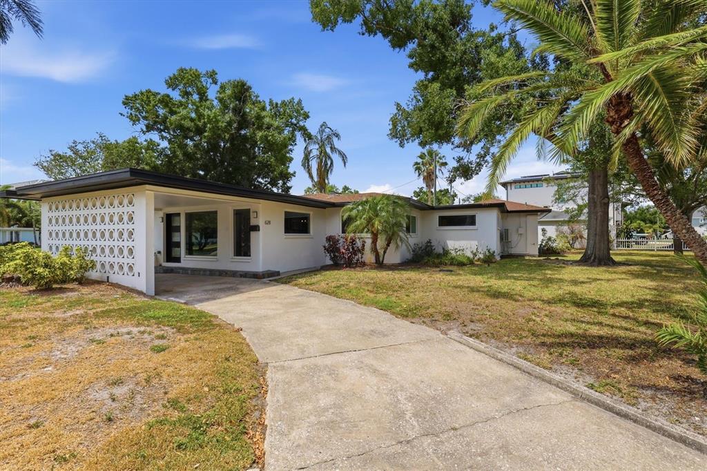 A single-story house with a concrete driveway, carport, and decorative breeze block wall — 628 ONTARIO AVENUE, TAMPA, FL