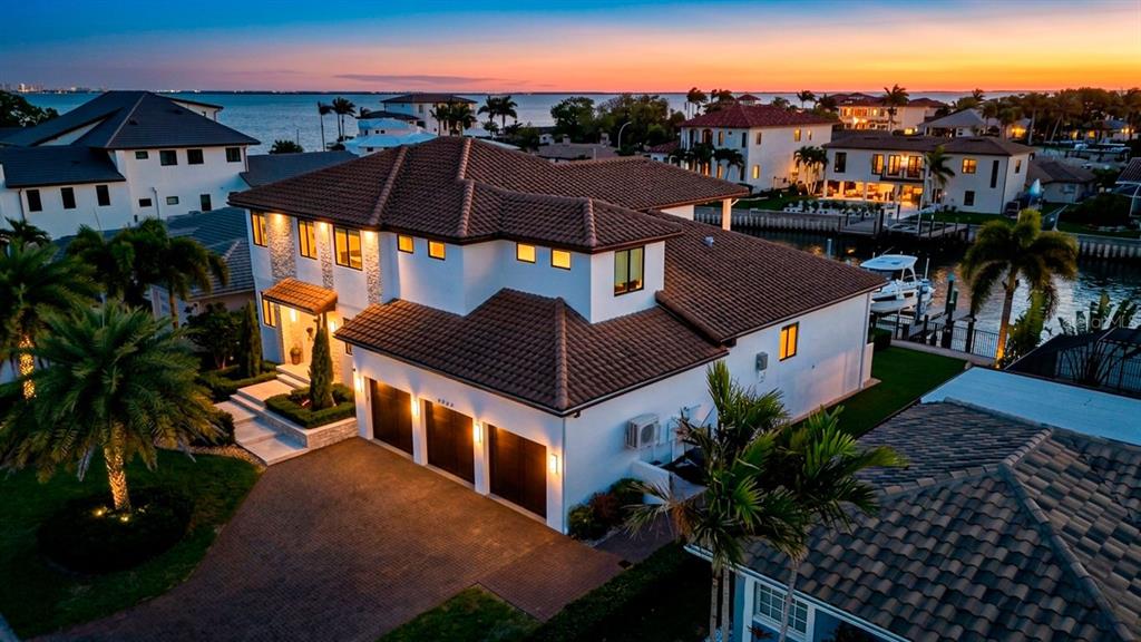 An aerial view of a two-story waterfront home with a tile roof and three-car garage — 2060 ILLINOIS AVENUE NE, ST PETERSBURG, FL