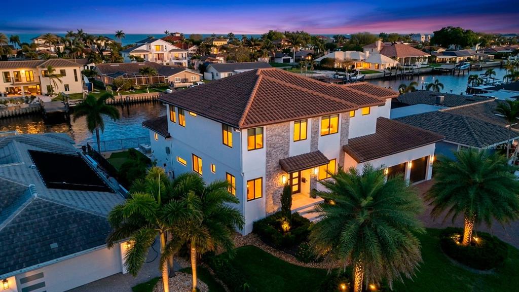 An aerial view of a multi-story waterfront home with a tile roof and palm trees — 2060 ILLINOIS AVENUE NE, ST PETERSBURG, FL