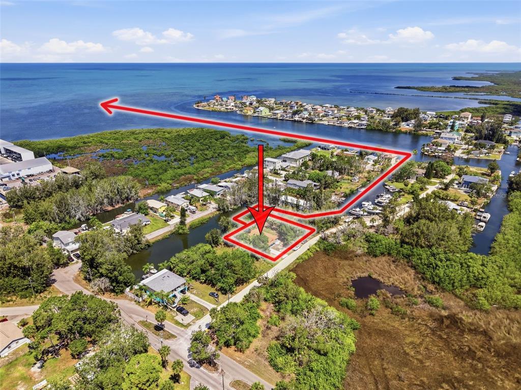 An aerial view shows a residential lot outlined in red near a canal and bay — 14339 RICE ROAD, HUDSON, FL