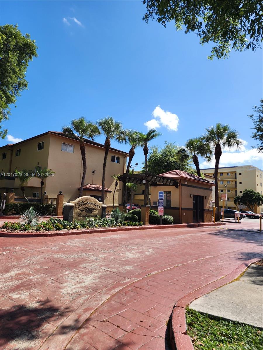The exterior of a Waterview condominium complex features a gated entrance with palm trees — 14901 SW 82nd Ter # 103, Miami FL 33193, MIAMI, FL