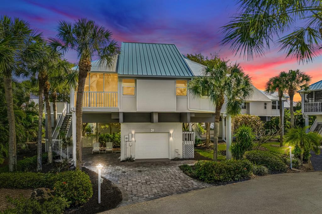 A two-story house with a metal roof, elevated living area, and a paved driveway — 5000 GASPARILLA ROAD UNIT VH20, BOCA GRANDE, FL