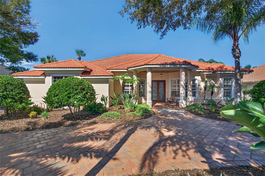 A single-story house with a terracotta tile roof and a paved driveway entrance — 8 OLD OAK DRIVE N, PALM COAST, FL