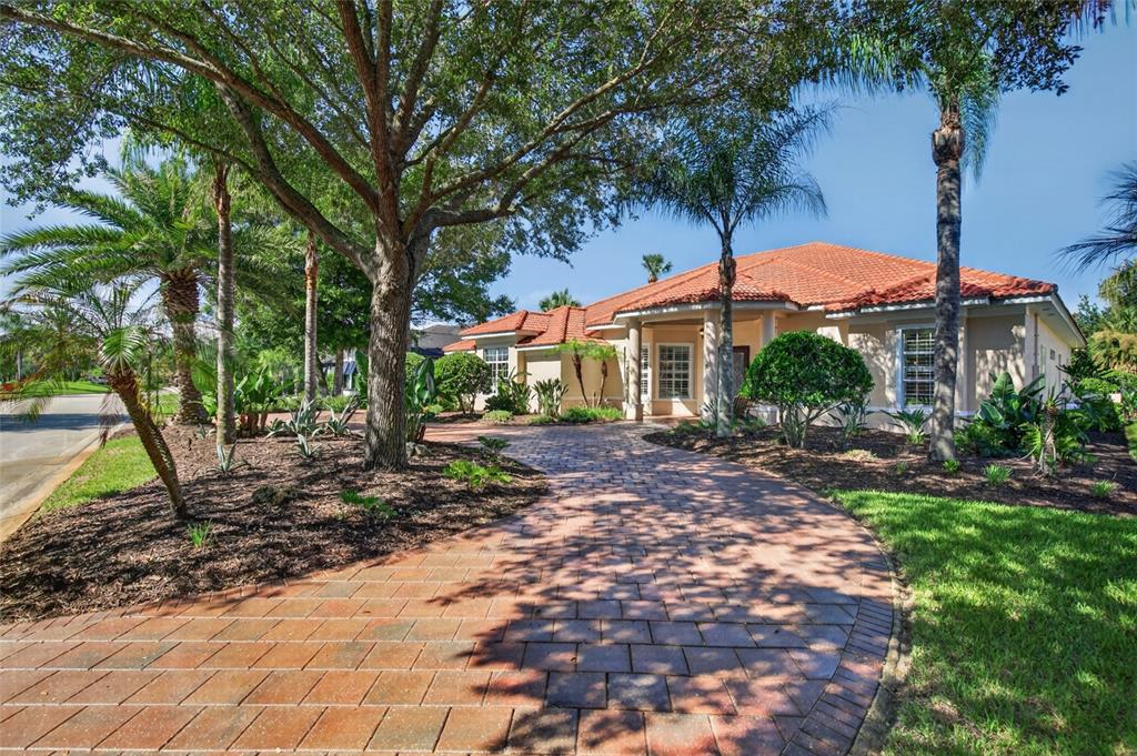 A single-story house with a terracotta tile roof and a paved driveway surrounded by trees — 8 OLD OAK DRIVE N, PALM COAST, FL