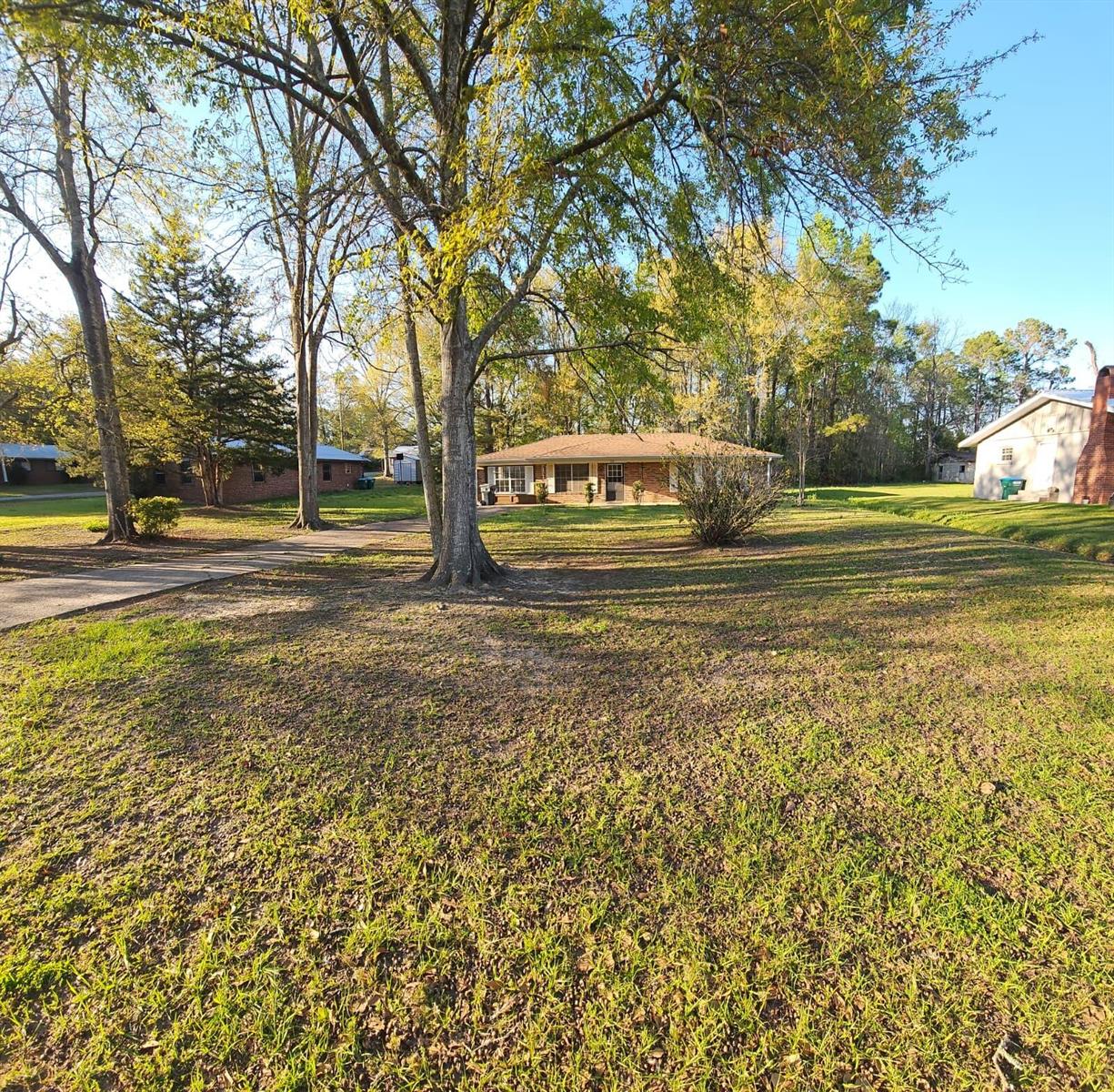 A single-story brick house sits on a large, grassy lot with mature trees — 503 Martin Luther King Junior Avenue, FL 32425, FL