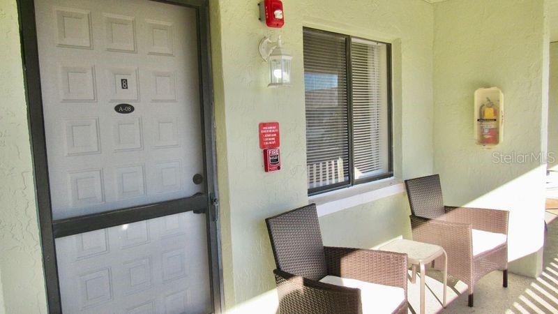 A patio area features a door labeled A-08, two wicker chairs, and a wall-mounted fire extinguisher — 20853 HAULOVER COVE UNIT A8, LUTZ, FL