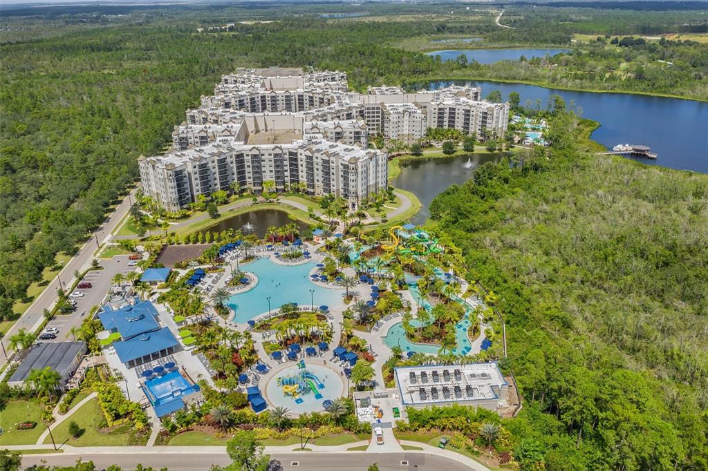 Aerial view of a large resort complex featuring multiple pools, water slides, and surrounding lakes — 14501 GROVE RESORT AVENUE UNIT 1111, WINTER GARDEN, FL