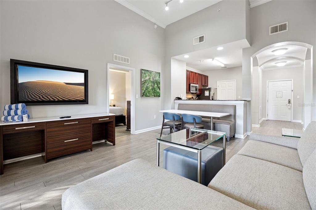 A living room with a television, sofa, dining area, and kitchen in an open floor plan — 14501 GROVE RESORT AVENUE UNIT 1111, WINTER GARDEN, FL