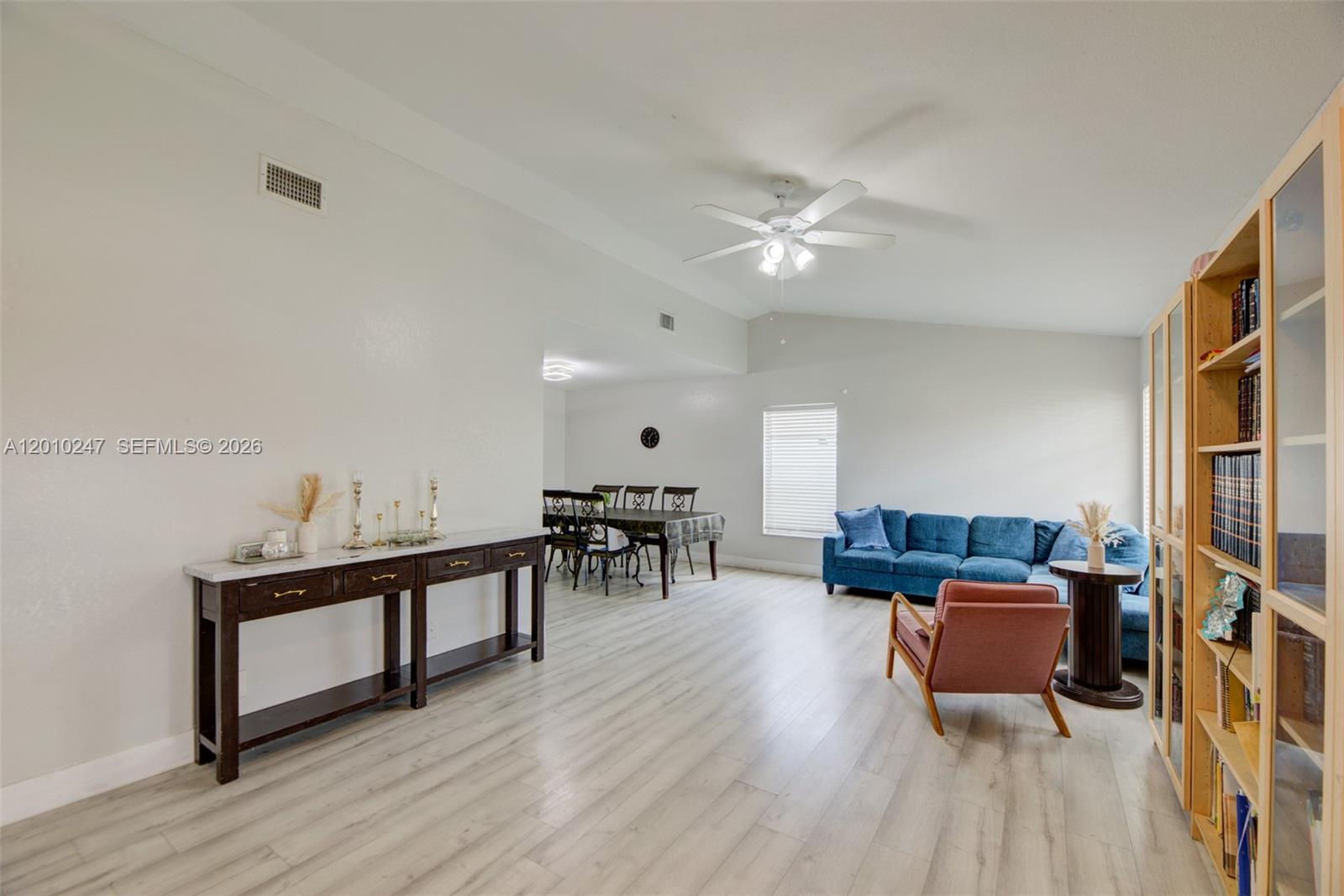 A living and dining area features light wood-look flooring, white walls, and a ceiling fan — 7454 NW 48th Pl, Lauderhill FL 33319, LAUDERHILL, FL