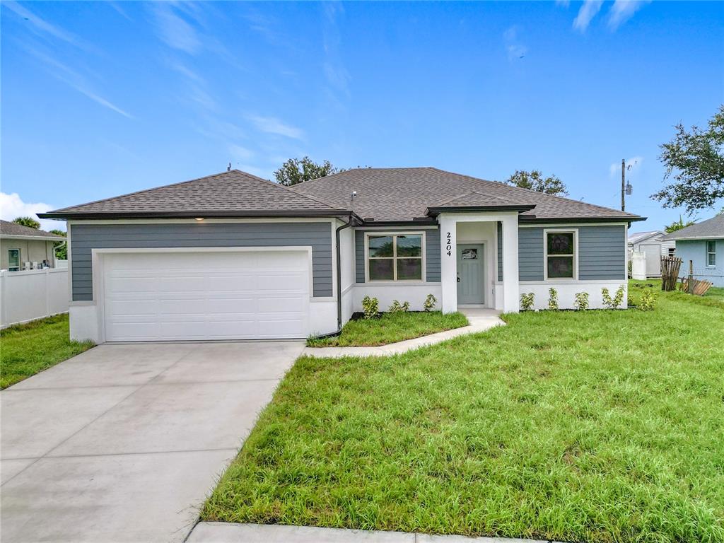 A single-story house with gray horizontal siding, white stucco, and a two-car garage — 1211 S SAN MATEO DRIVE, NORTH PORT, FL