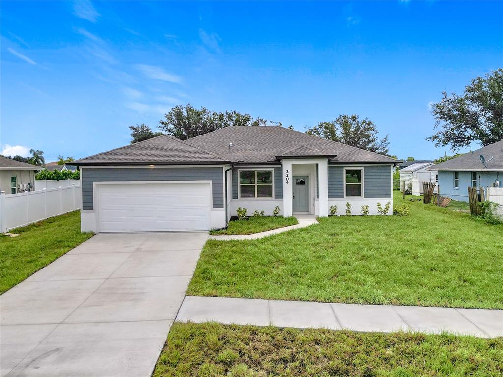 A single-story house with a gray exterior, white trim, and a two-car garage — 1211 S SAN MATEO DRIVE, NORTH PORT, FL