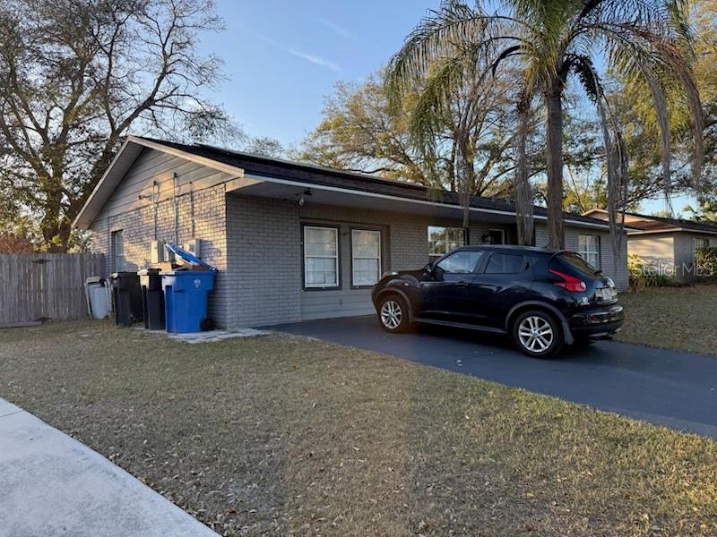 A gray brick single-story house with a black car parked in the driveway — 4906 PRESIDENTIAL STREET, SEFFNER, FL