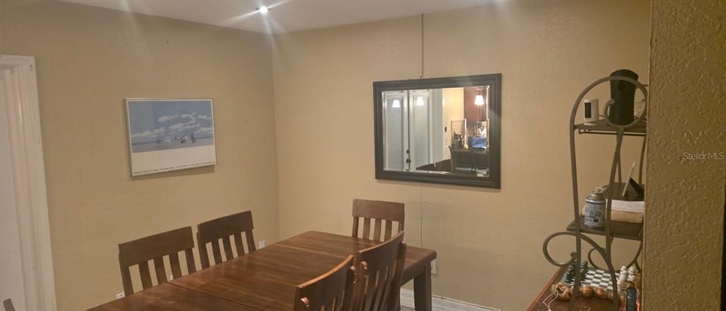 A dining room features a wooden table, chairs, a framed print, and a wall mirror — 4906 PRESIDENTIAL STREET, SEFFNER, FL