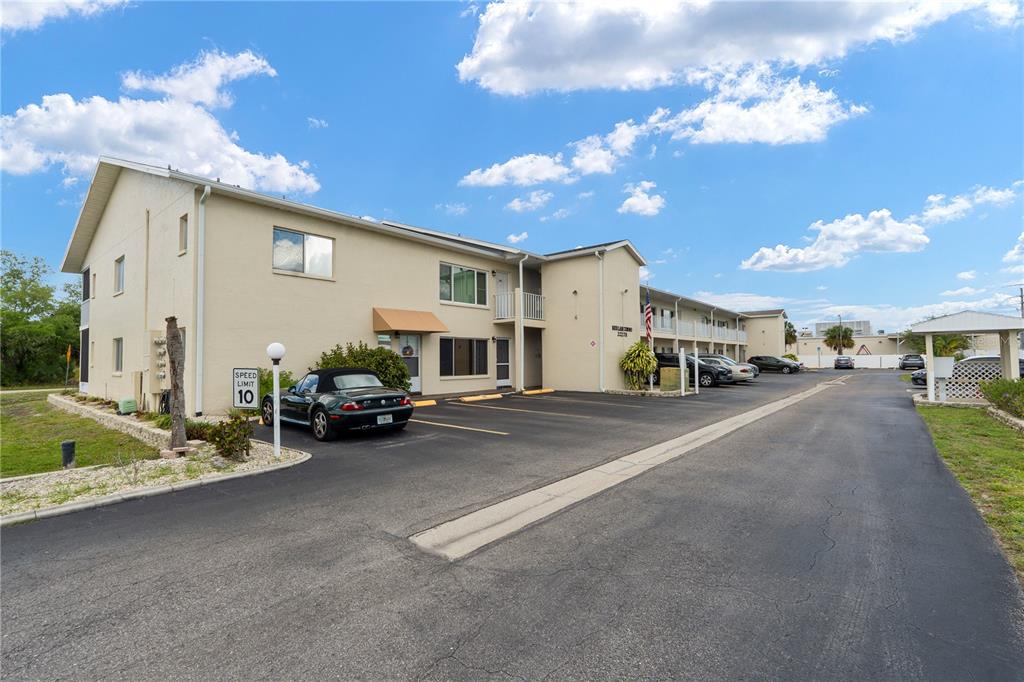 A two-story apartment building with a parking lot and a speed limit sign — 22278 VICK STREET UNIT A112, PUNTA GORDA, FL